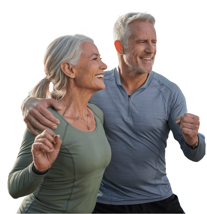An active couple in their 50s, smiling and on the move